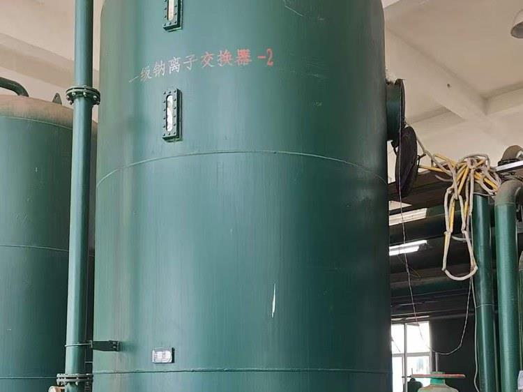 钠离子交换器罐体外观：罐壁上的设备标识，旁侧为控制柜与进出水管路