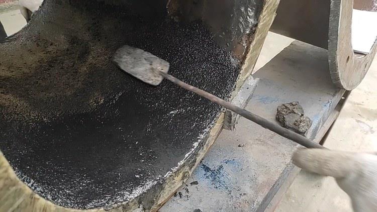 管件内壁耐磨涂层铺满，表面呈骨料颗粒质感，初固前用批刀修平